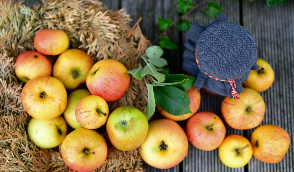 Много спелых яблок на столе с вареньем 