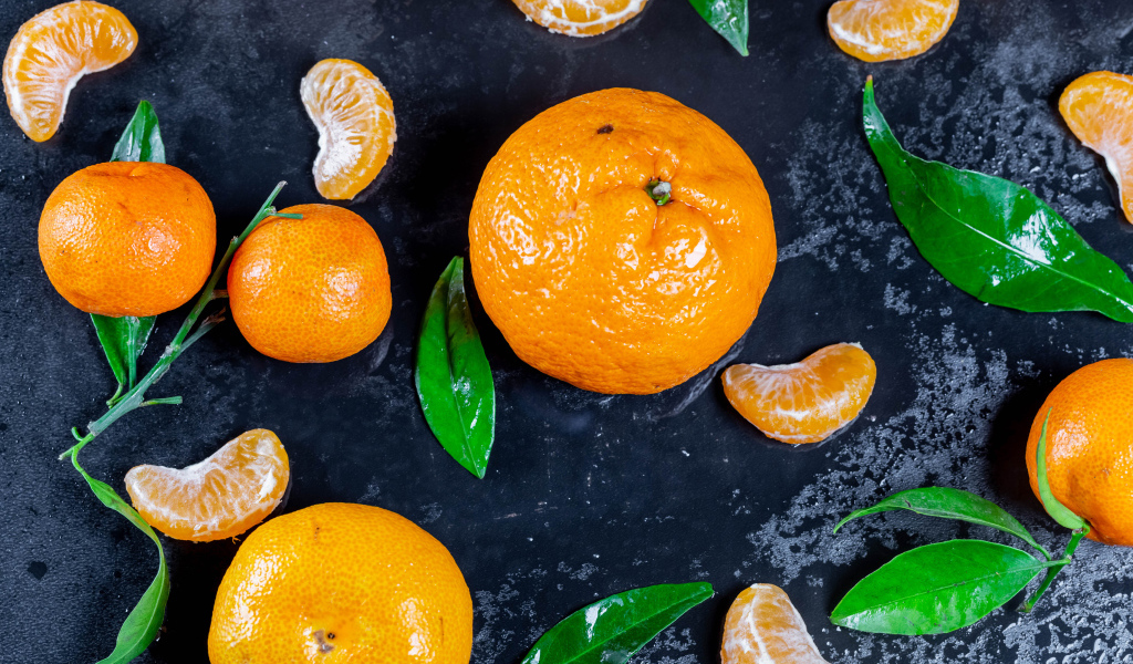 Оранжевые мандарины на мокрой поверхности 