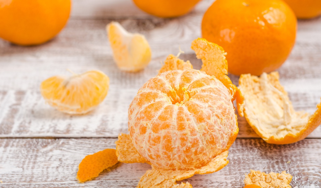 Очищенный мандарин на деревянном столе 