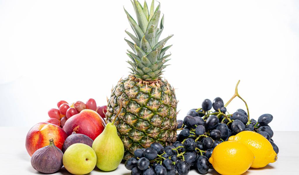 Ананас, виноград, инжир, лимон, нектарин и груши на белом фоне