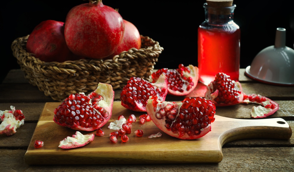 Плоды граната на столе с соком 