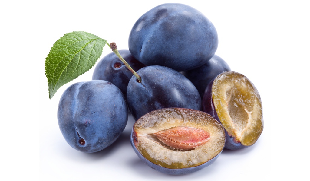 Спелые синие сливы на белом фоне