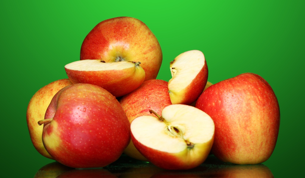 Спелые вкусные красные яблоки на зеленом фоне