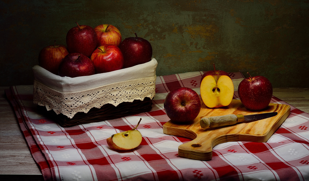 Спелые красные яблоки на столе с ножом