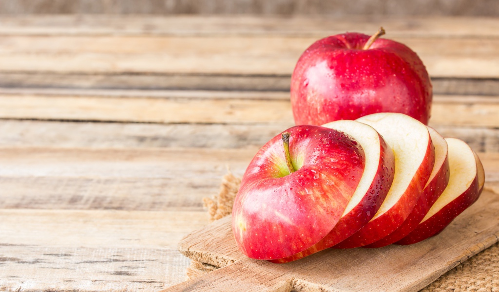 Нарезанное яблоко на разделочной доске 