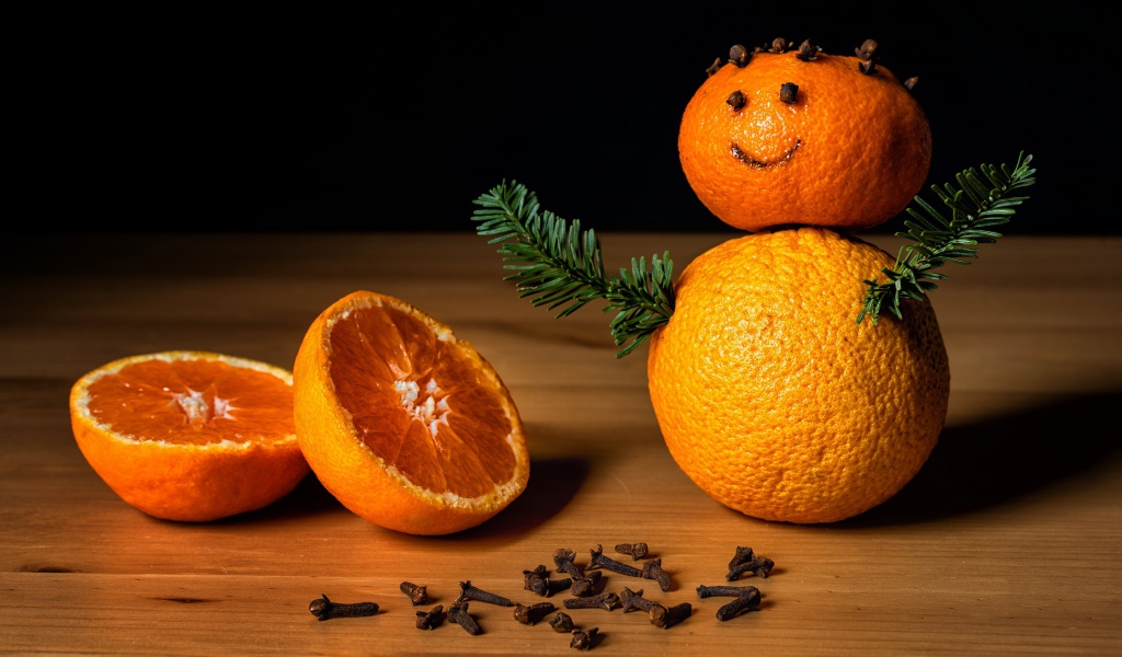 Снеговик из мандаринов и корицы на столе 