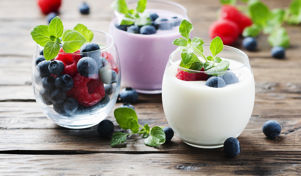 Вкусный йогурт с ягодами черники и малины на столе 