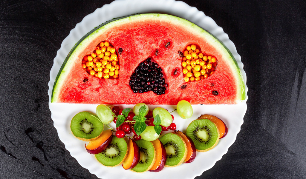 Арбуз на тарелке с ягодами 