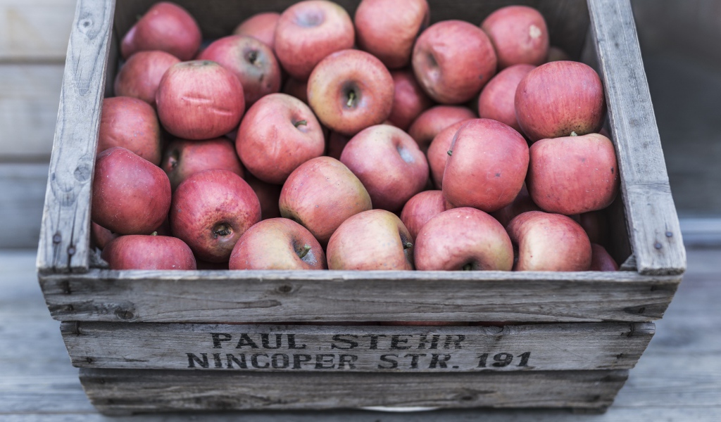 Деревянный ящик с красными спелыми яблоками