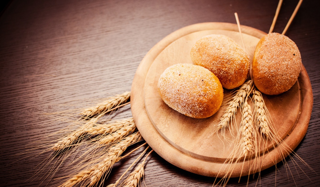 Свежий хлеб с колосьями пшеницы на доске