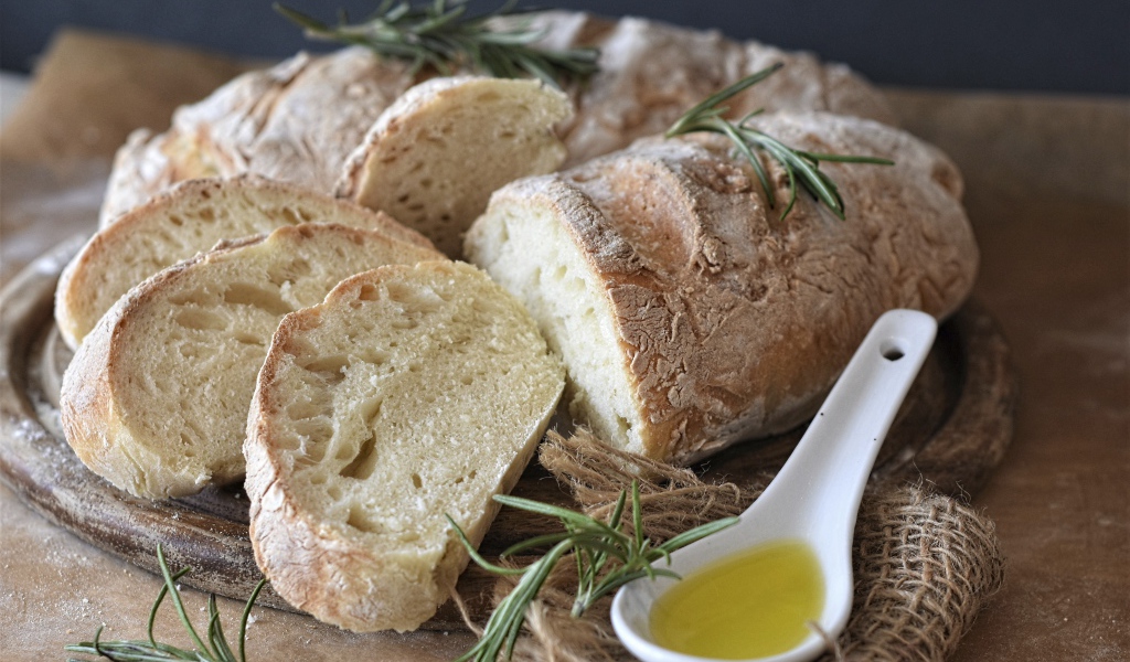 Fresh loaf on the table with rosemary and butter