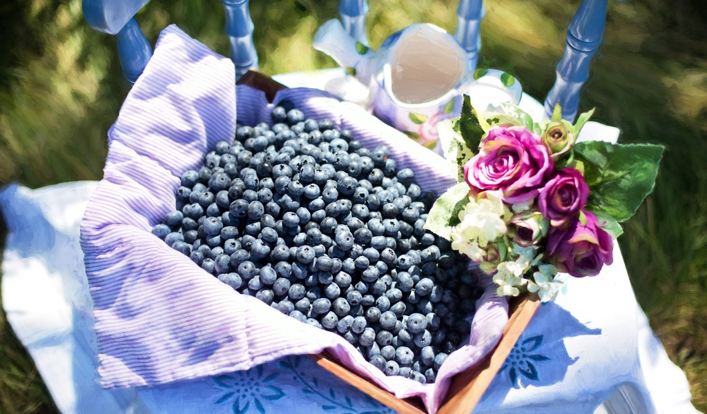 Корзина со спелыми ягодами черники стоит на столе