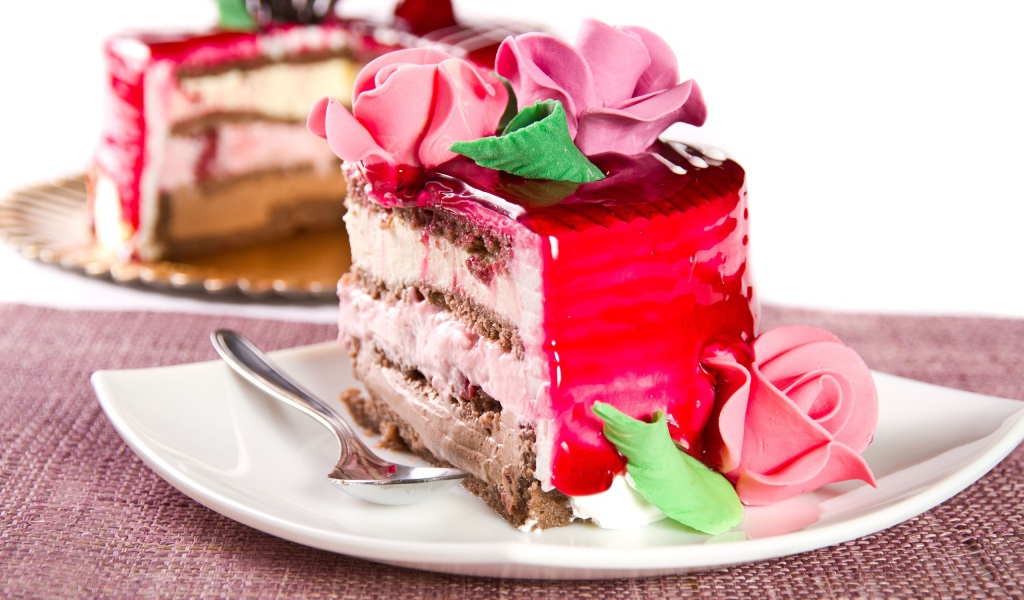 Кусок аппетитного торта декорирован розами из крема