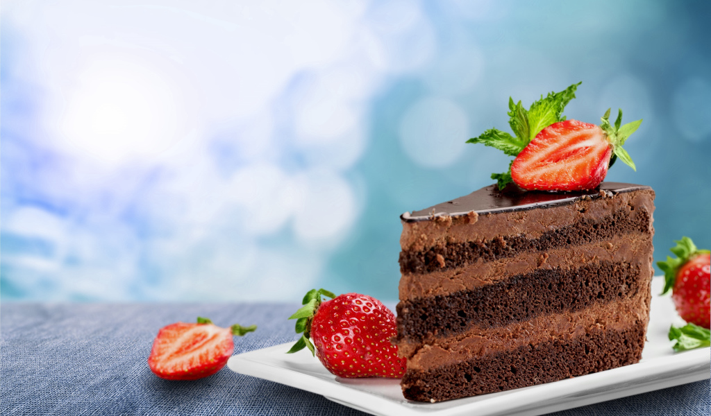 Кусок аппетитного торта с шоколадным кремом и клубникой 