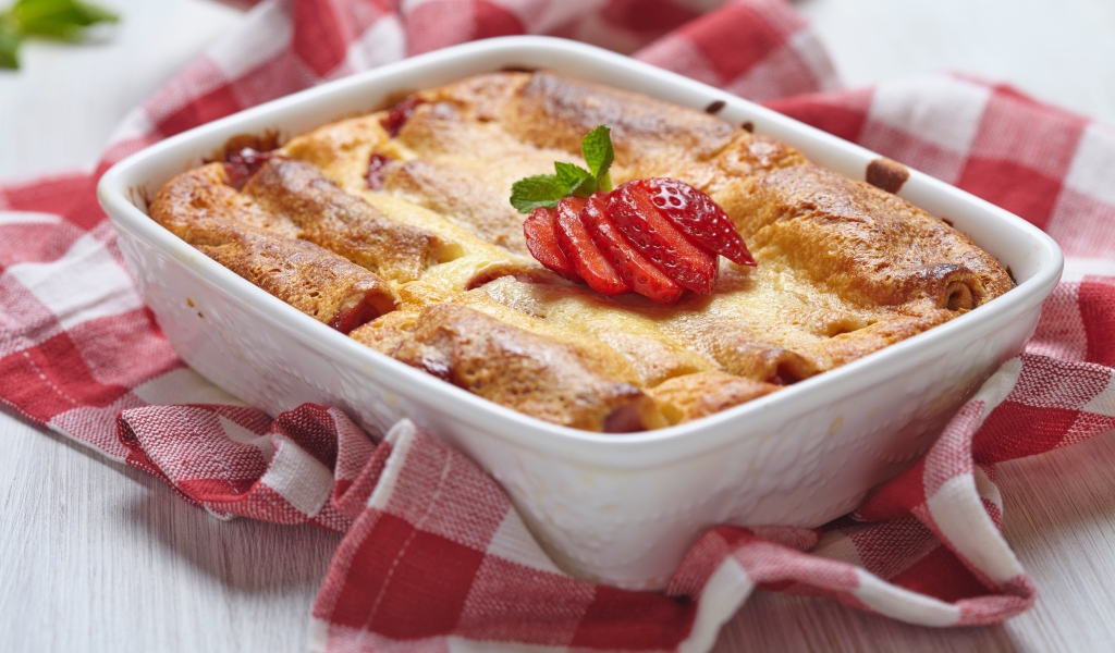 Аппетитный свежий пирог с клубникой на столе 