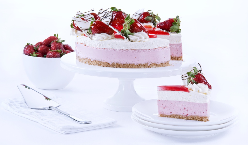 Аппетитный праздничный торт с клубникой на столе 