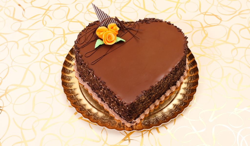 Красивый торт в форме сердца в шоколаде на столе