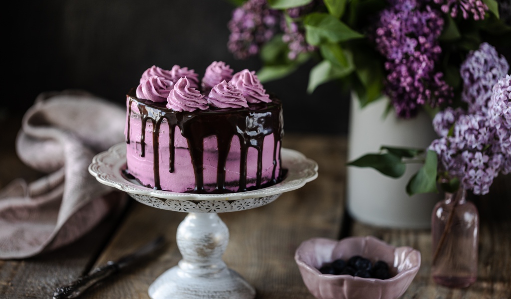 Ягодный торт с шоколадом на столе с сиренью 