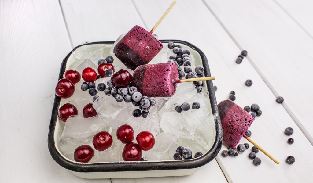 Ягодное мороженое в лотке со льдом, черникой и вишней 