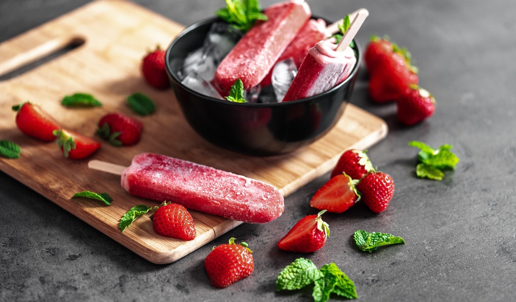 Ягодное мороженое с клубникой и мятой на столе 