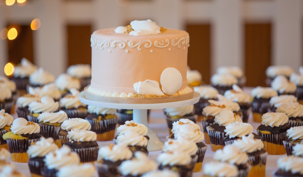 Праздничный торт с пирожными на столе 