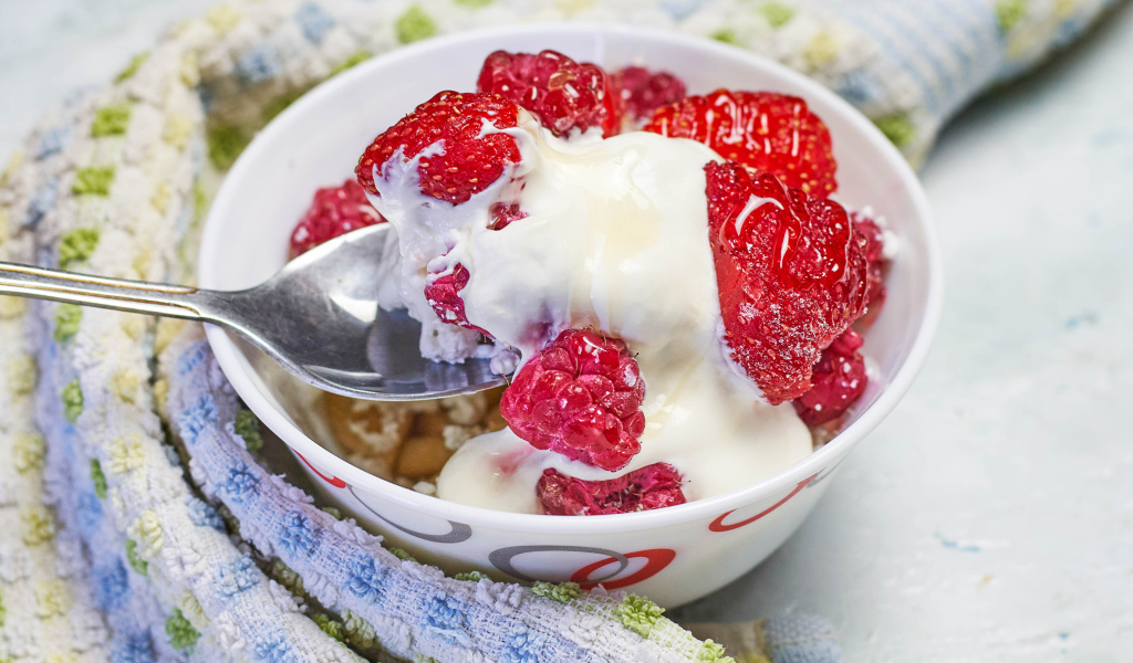 Завтрак с йогуртом и малиной в миске с ложкой