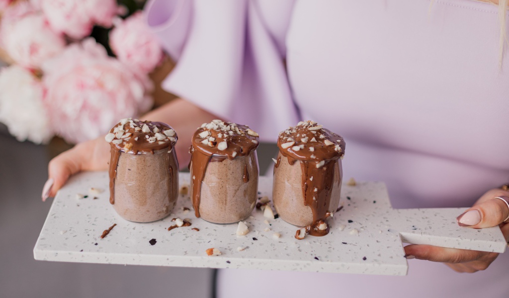 Шоколадный десерт в банках в руках у девушки