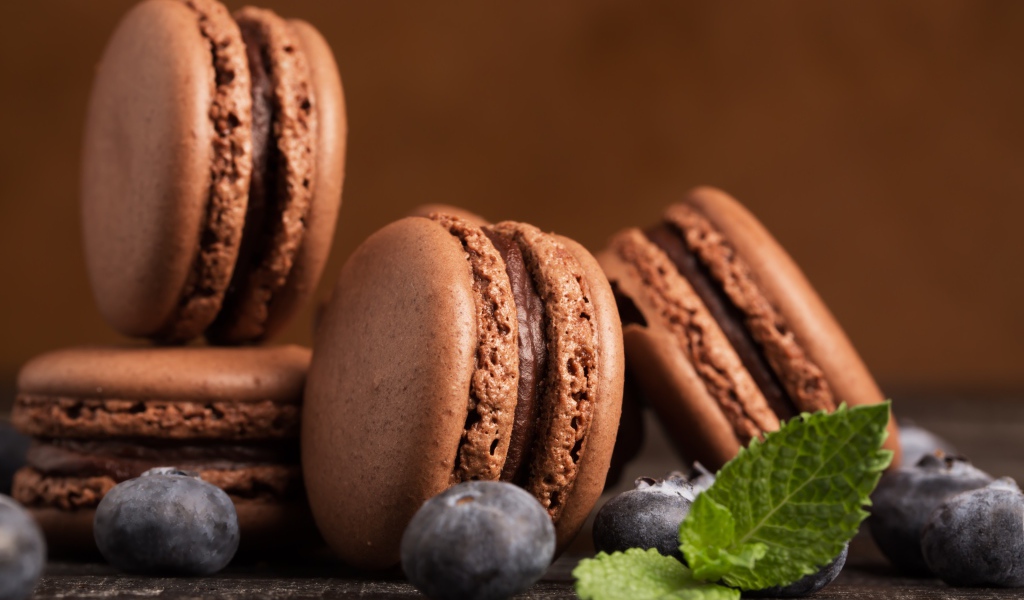 Шоколадный десерт макарон на столе с черникой 