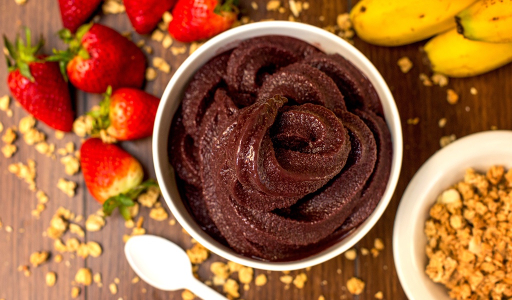 Шоколадная паста на столе с ягодами клубники и бананами