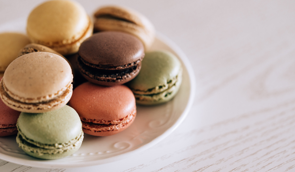 Разноцветный свежий десерт макарон на большой тарелке 