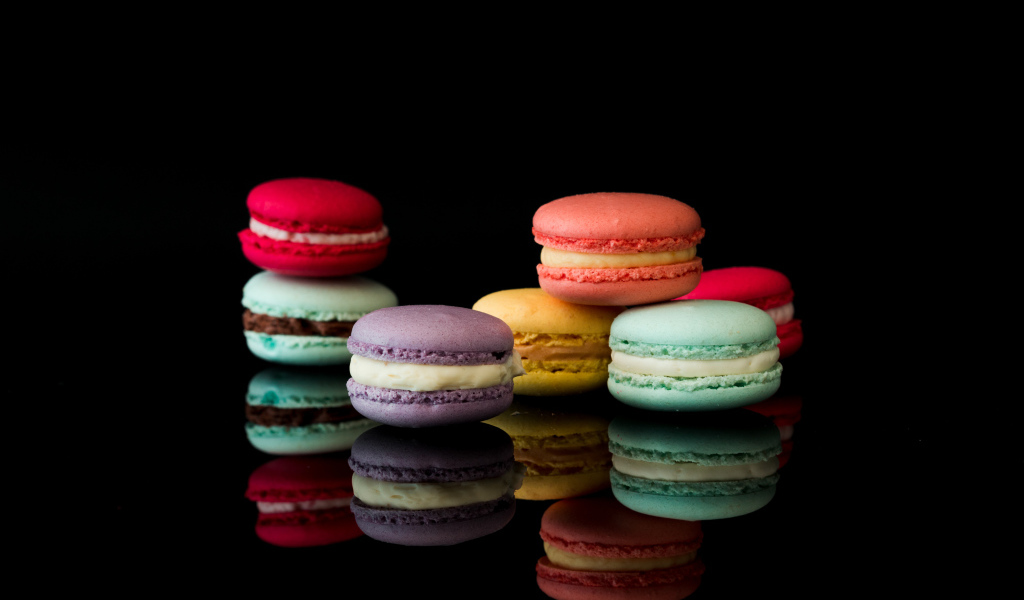 Разноцветный десерт макарун на черном фоне