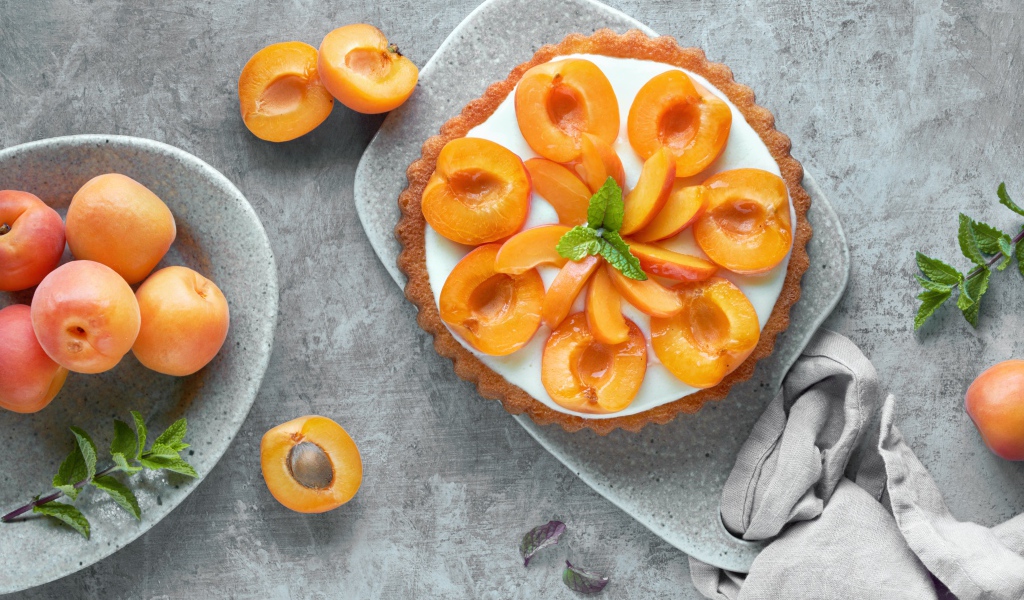 Пирог с кремом и абрикосами на столе 