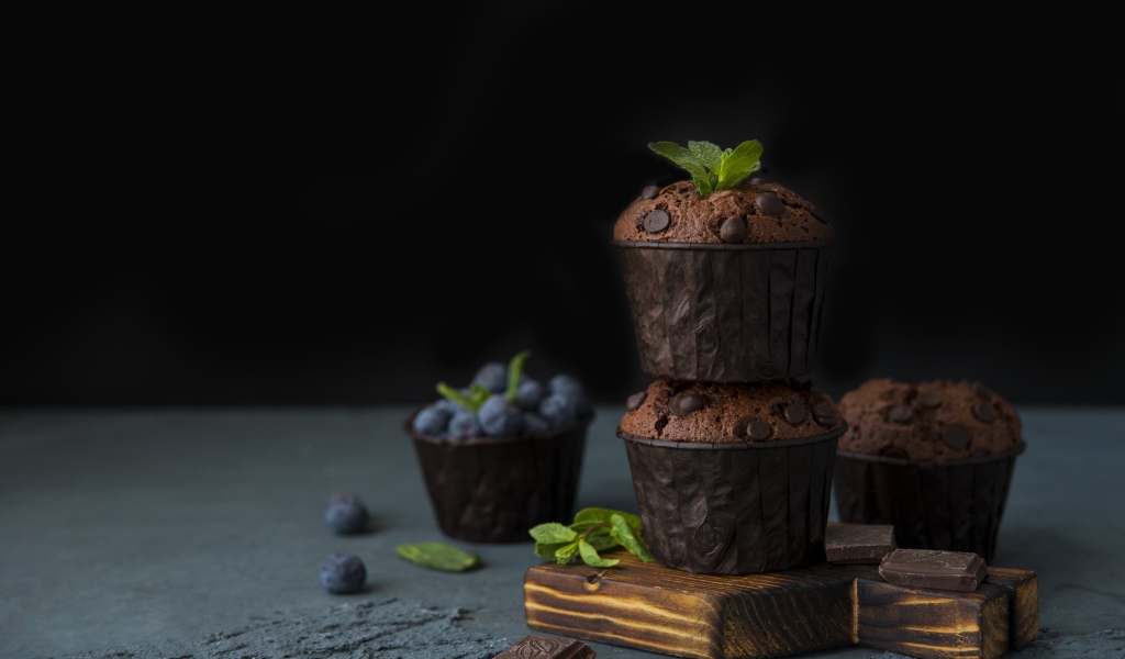 Кексы с шоколадом на столе с ягодами черники на столе 