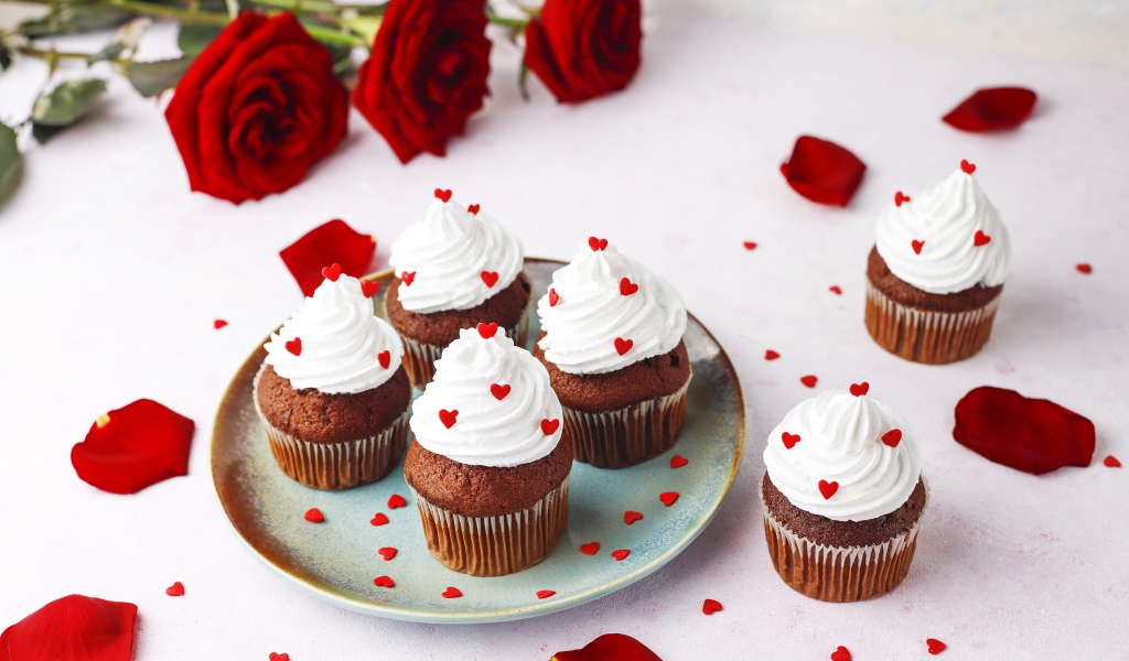 Кексы с кремом на столе с букетом роз 