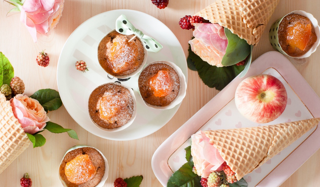 Вкусные кексы с абрикосом на столе с вафельными рожками с розой и ежевикой