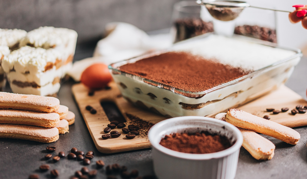 Десерт тирамису на столе с какао 