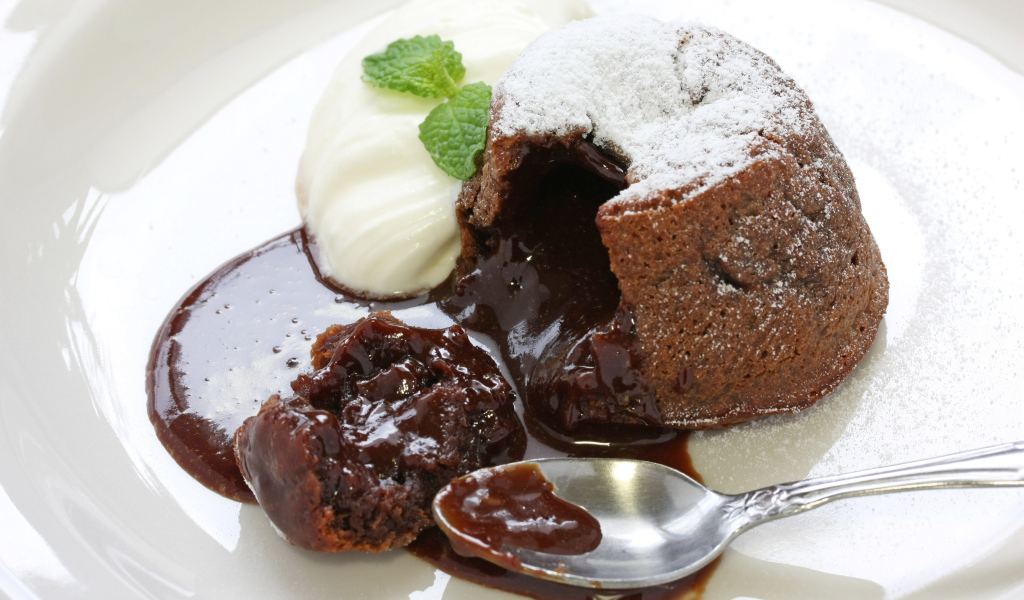 Десерт с шоколадом и сливками на белой тарелке 