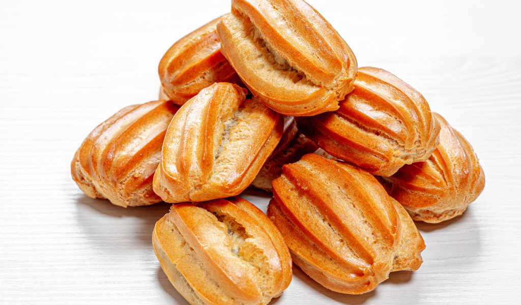 Свежие эклеры на белом фоне