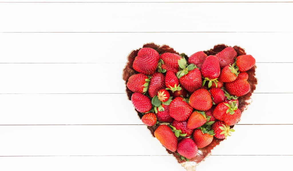 Пирожное в форме сердца с клубникой на белом фоне