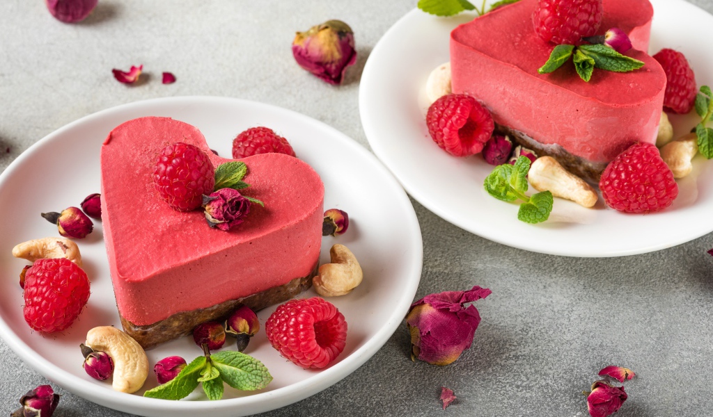 Фруктовое суфле в форме сердца на тарелке с малиной и орехами 