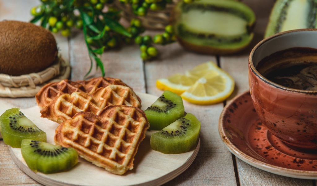 Вафли в форме сердца на доске с киви и чашкой кофе