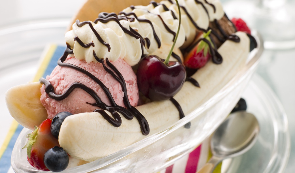 Шарики мороженого на тарелке с бананами и черешней 