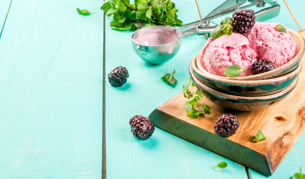 Шарики мороженого на столе с ягодами черники и мятой