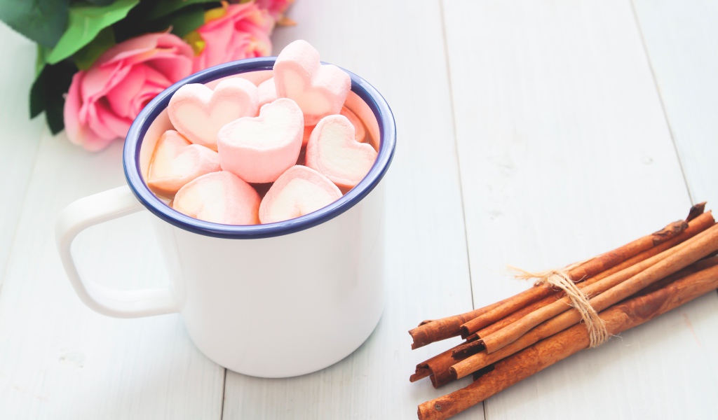 Железная чашка какао с маршмеллоу на столе с корицей 