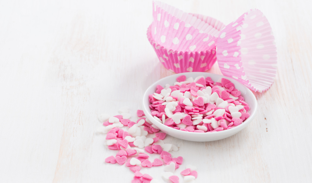 Маленькие белые и розовые сердечки на столе 