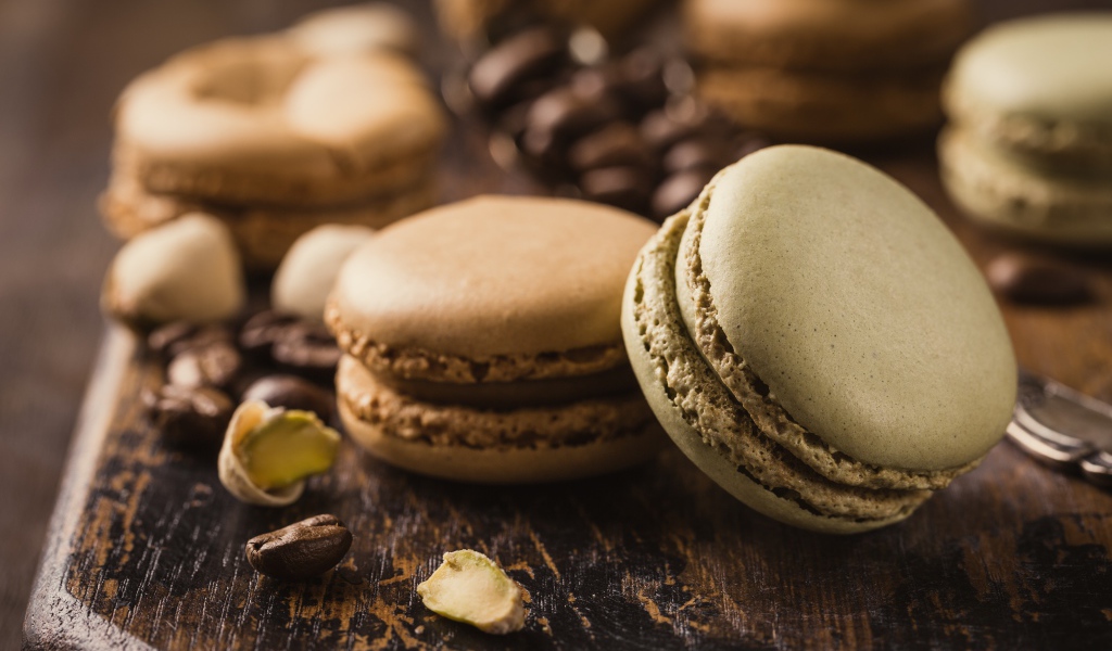 Десерт макарун на столе с кофейными зернами