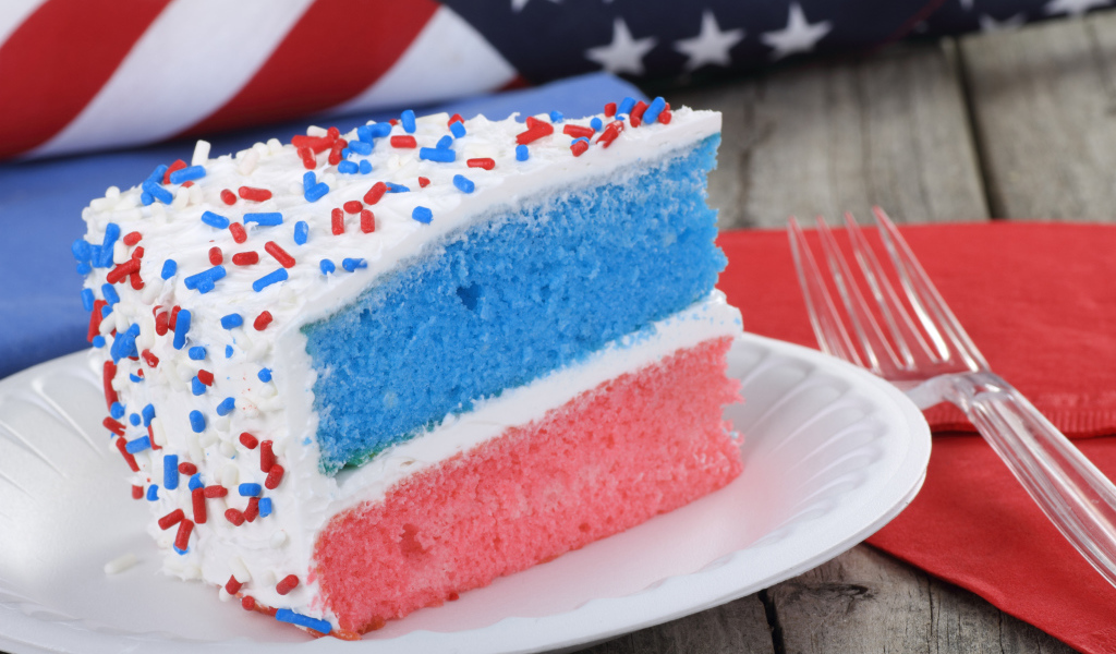 Разноцветный торт на тарелке с кремом