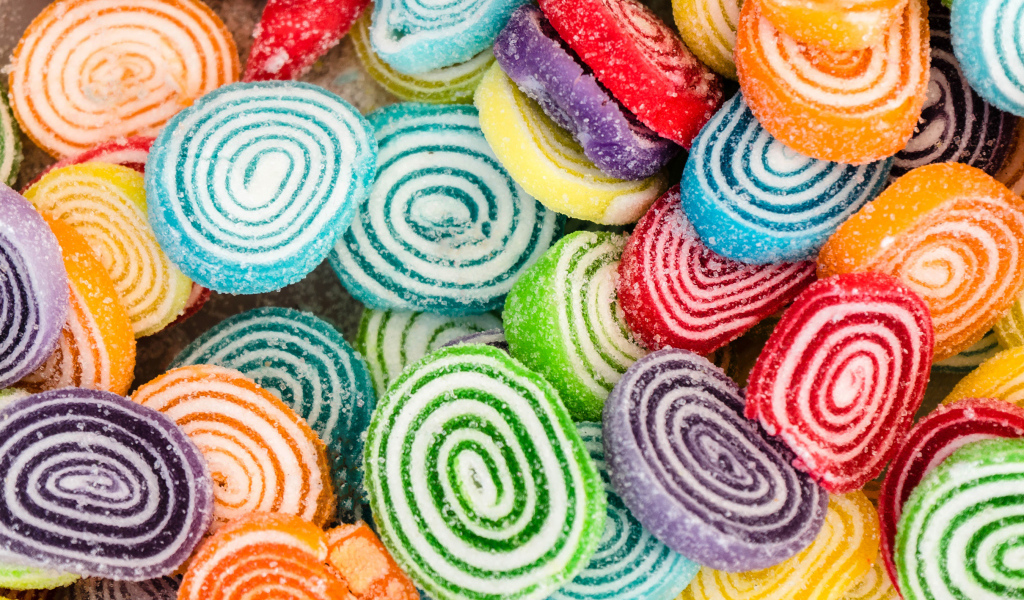 Разноцветный спиральный мармелад в сахаре крупным планом