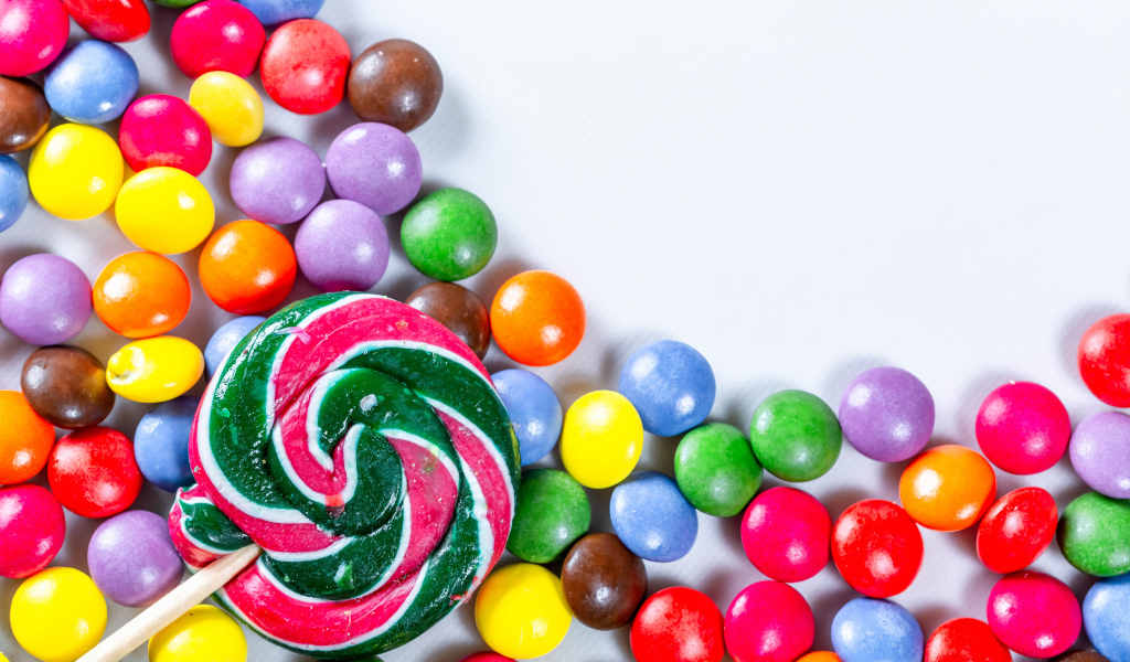 Разноцветные конфеты в глазури и карамель на белом фоне 