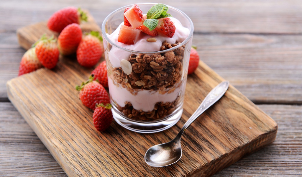 Овсяные хлопья в стакане с йогуртом и ягодами клубники